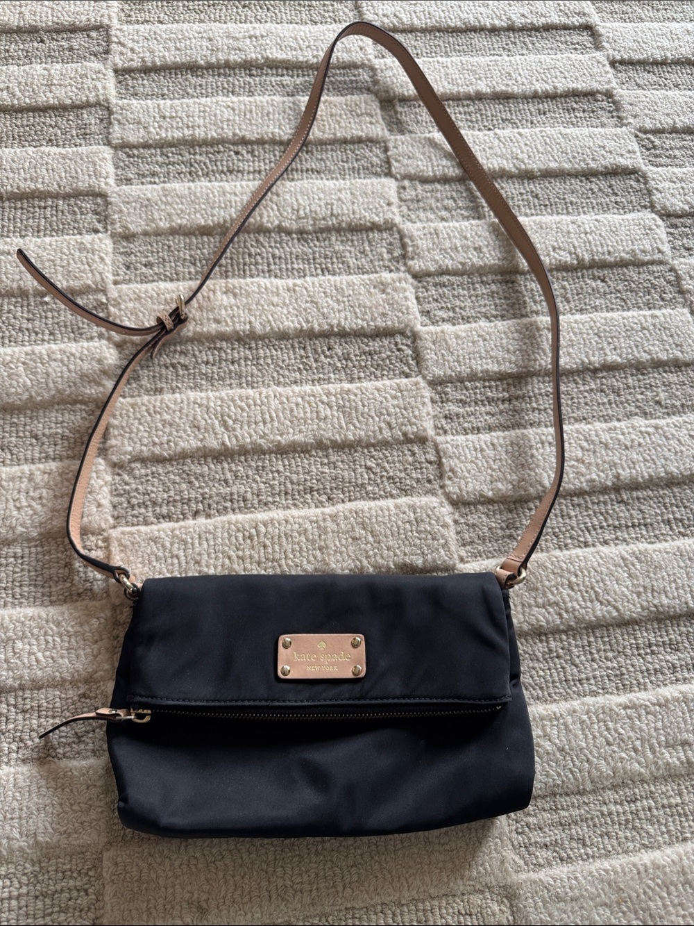 kate spade black crossbody with tan strap and gold logo plate